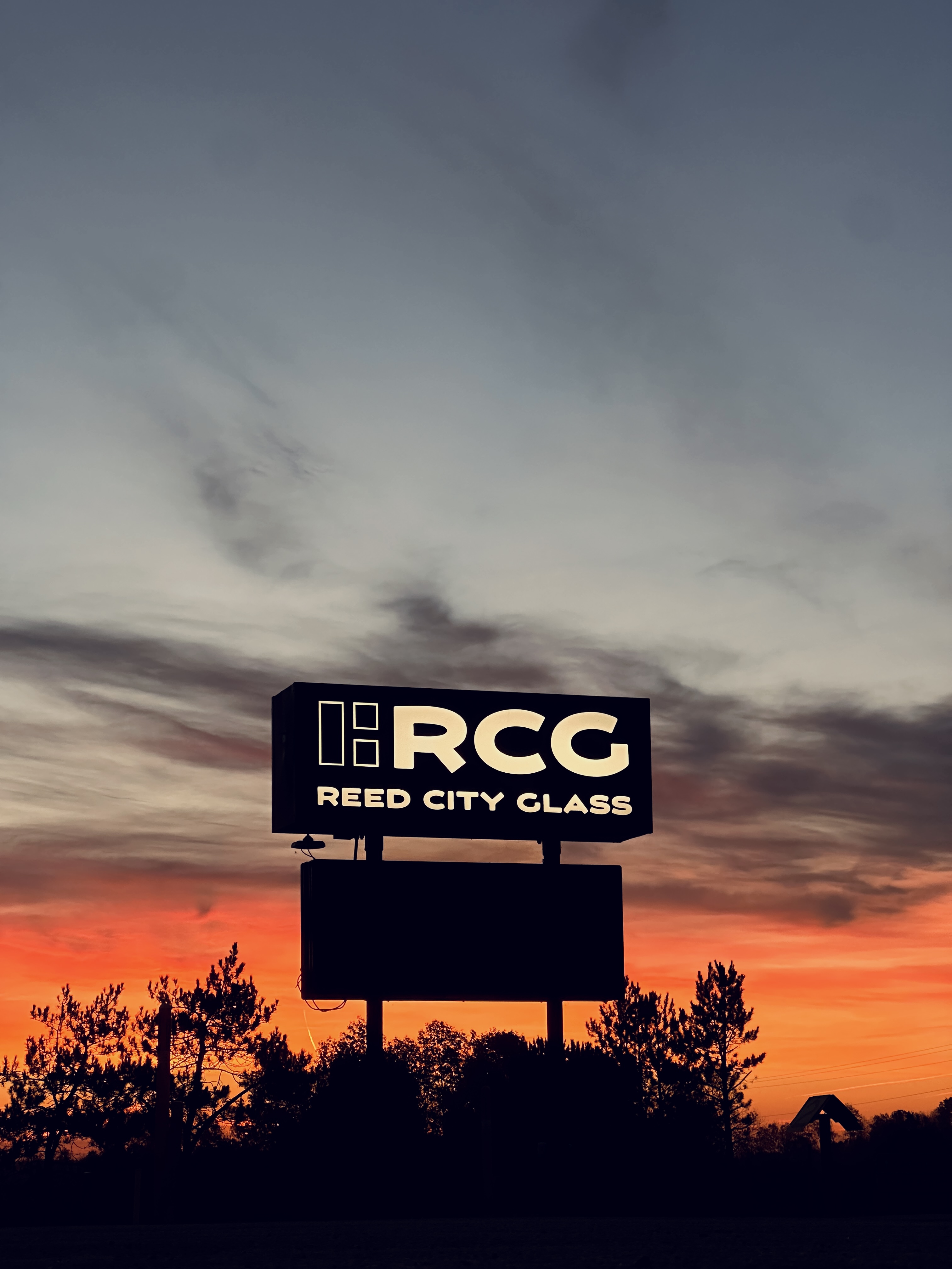 Reed City Glass sign at sunset — Reed City Michigan